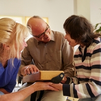 3 Personen schauen zu einander bei der Musiktherapie
